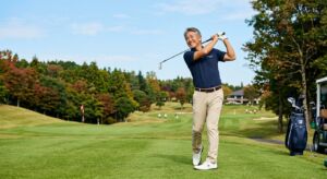 50代男性ゴルファーがゴルフ場でプレーしている様子